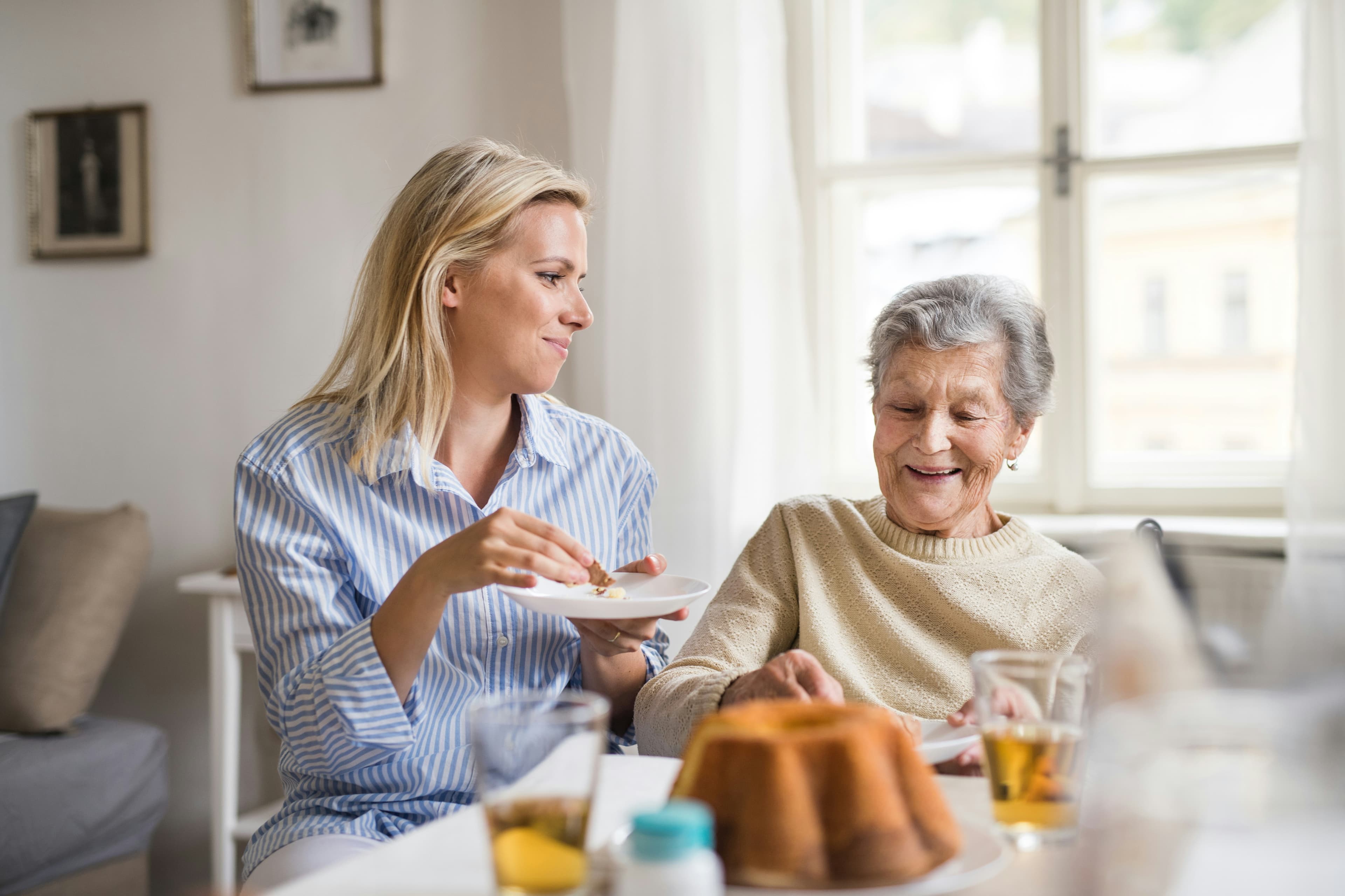 An older relative's hand held by a younger family member, representing aged care support