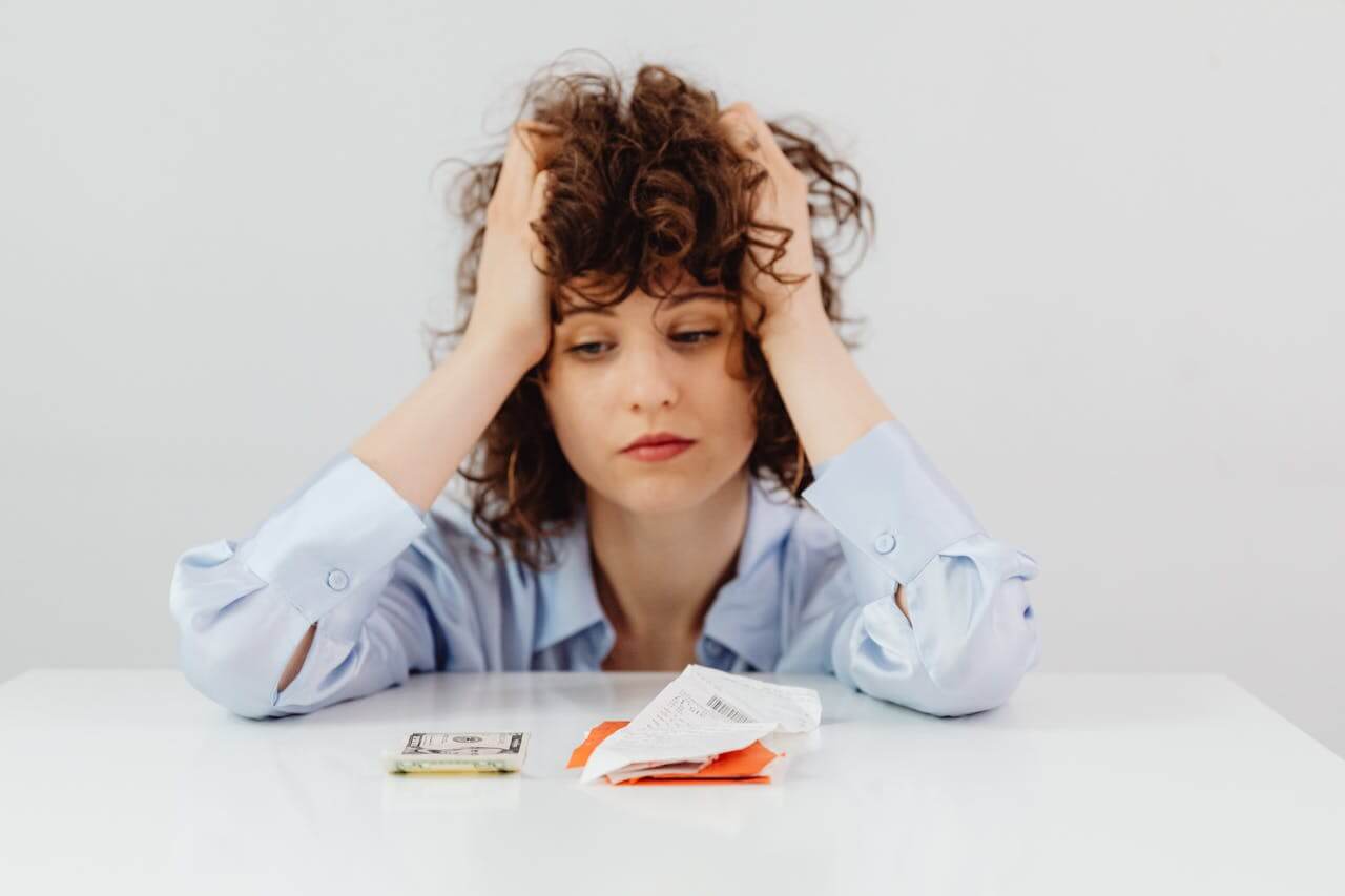 Stressed woman at desk with financial documents